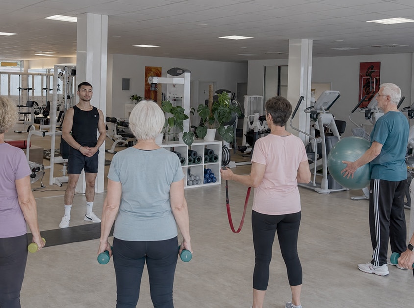 Rehasport-Gruppe mit Trainer auf der Trainingsfläche